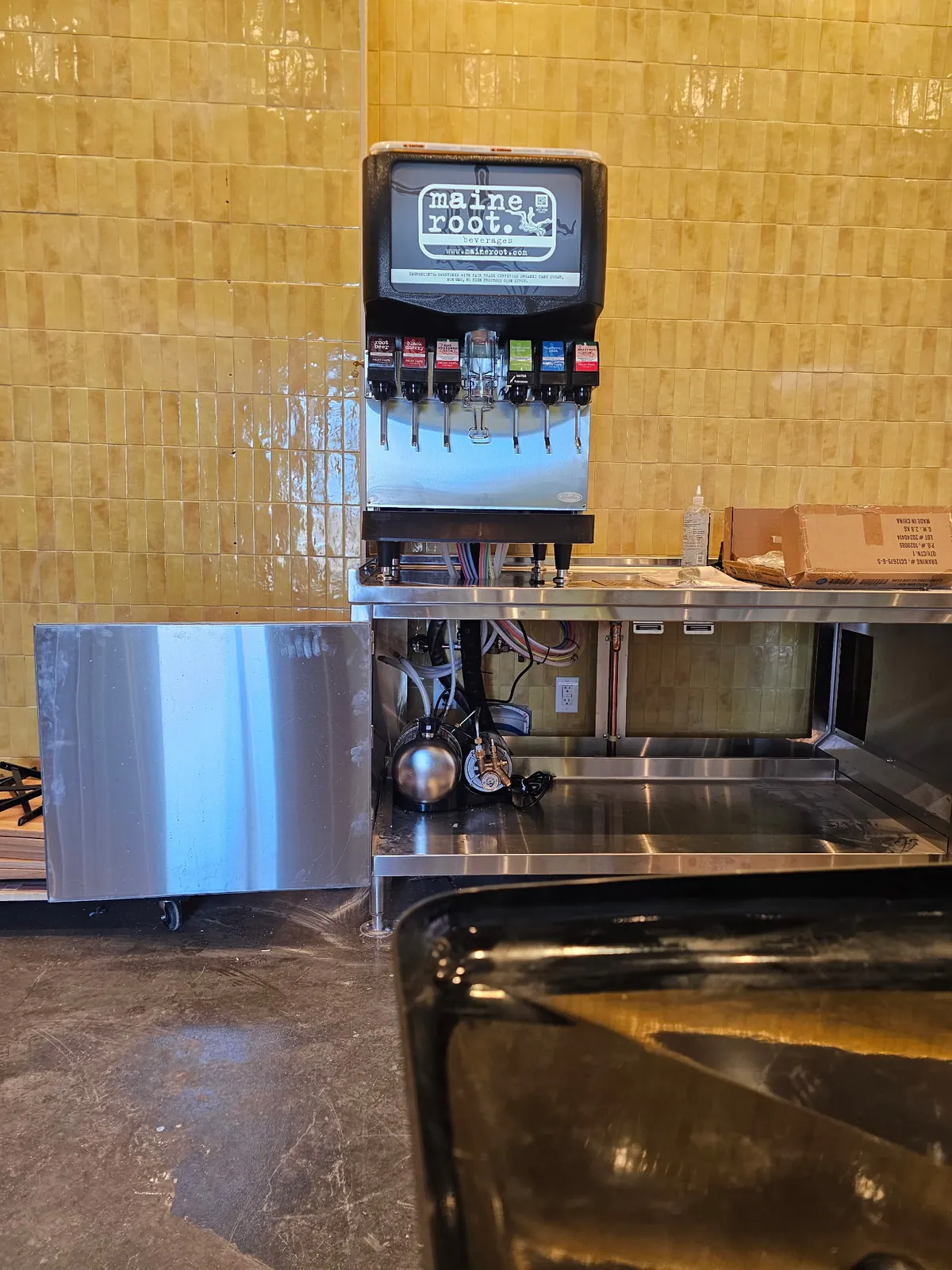Cornelius fountain head on a stainless counter with the syrup lines and pump run underneath