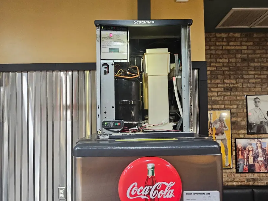 Scotsman ice machine head opened for service above a Coca Cola fountain at a Raising Cane's