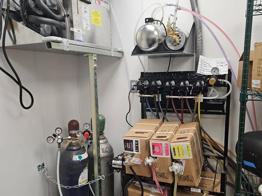 Bag in box syrup rack, carbonator and CO2 cylinders installed in a back room at Truland Burgers and Greens